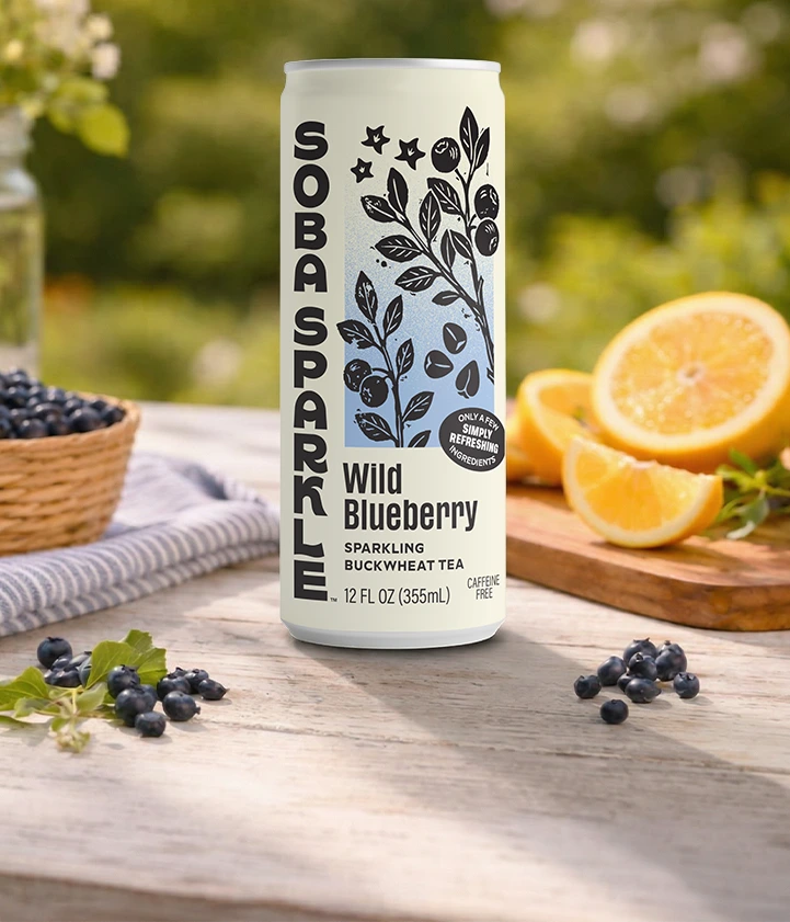 Sparklebuck Wild Blueberry sparkling buckwheat tea can on a wooden table with blueberries and oranges.